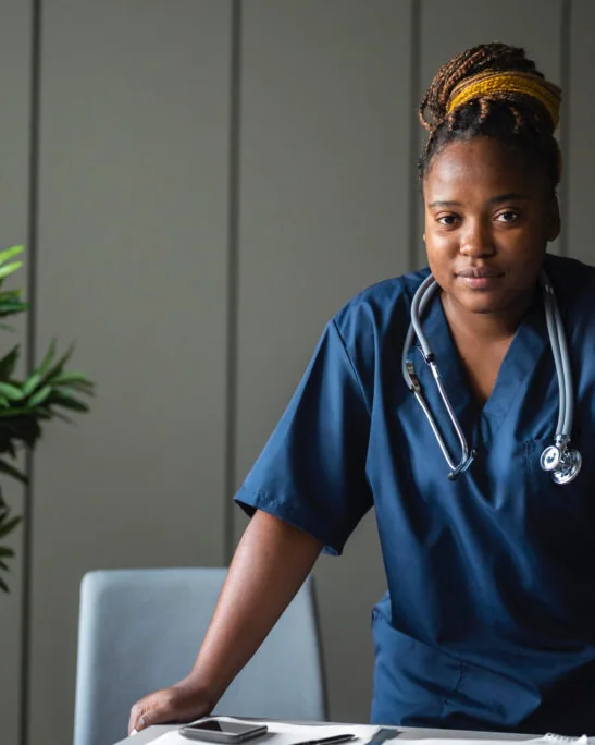 A young Insyt nurse in scrubs with a stethoscope, trained to manage recovery at home after surgery.
